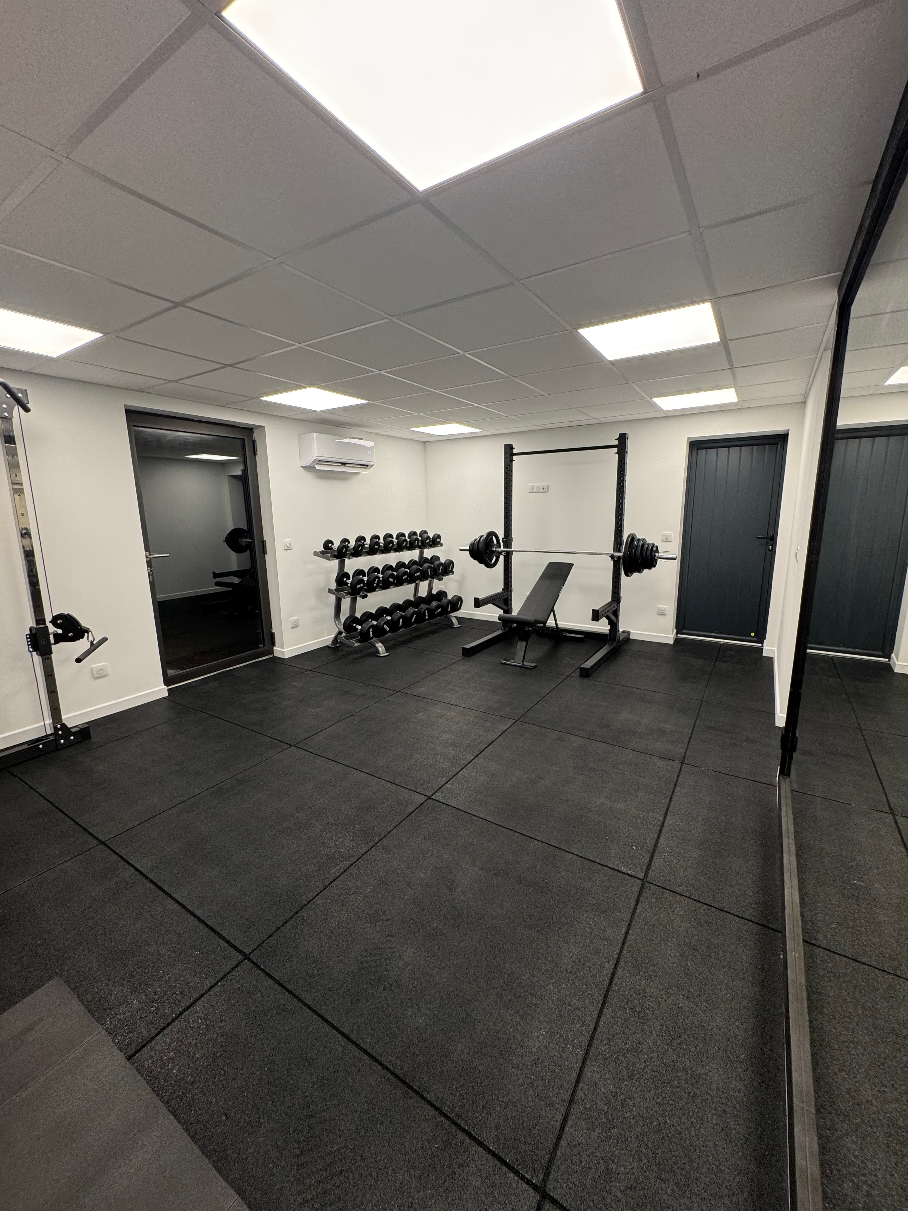 Vue d'ensemble du studio avec sac de frappe et air bike